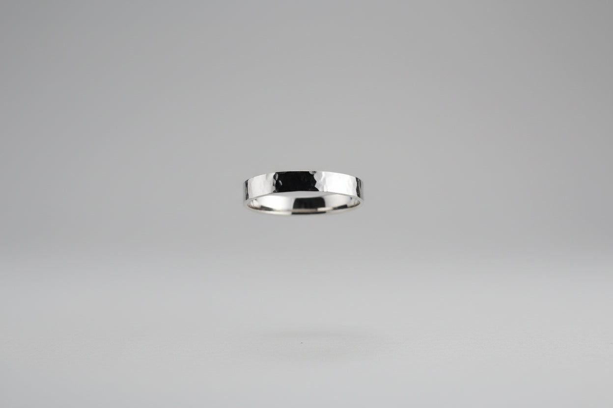 Textured Band - Another Angle
Ring Size: US 11.75
Materials: Solid sterling silver (925)
Finish: Hand-hammered, oxidized and polished to highlight texture
Style: Minimal and bold — perfect for stacking or solo wear
Background: Pink salt lamp, green bell, shrubbery